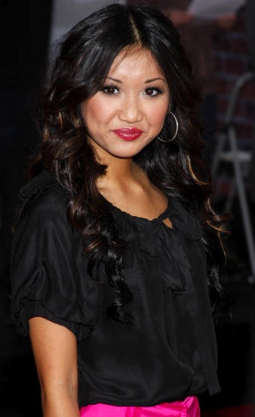 Here Brenda Song is wearing a black top and pink skirt